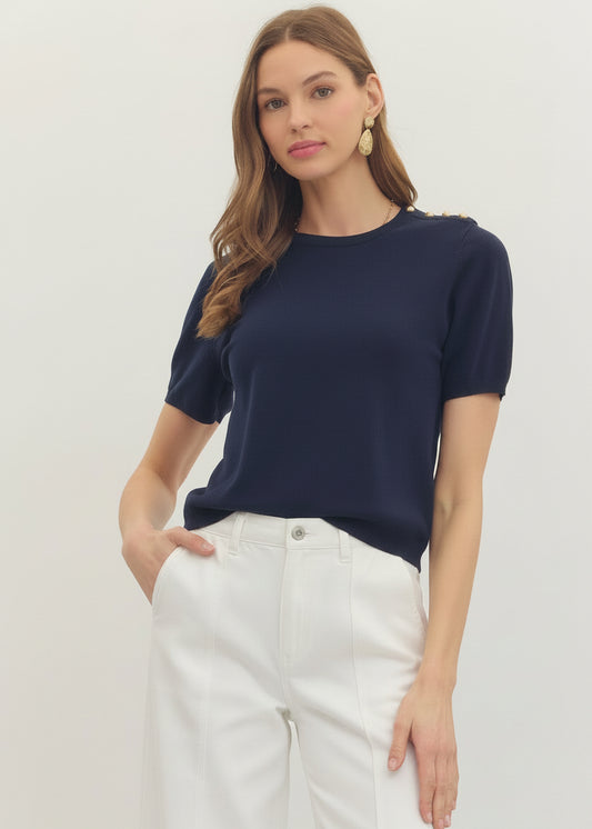 Woman wearing a navy blue top and pants on a light gray background