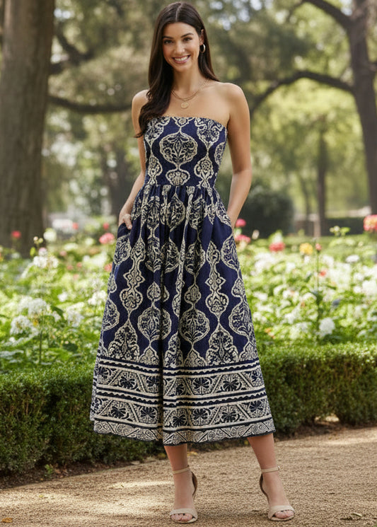 Woman wearing a strapless navy and white patterned dress on a light background