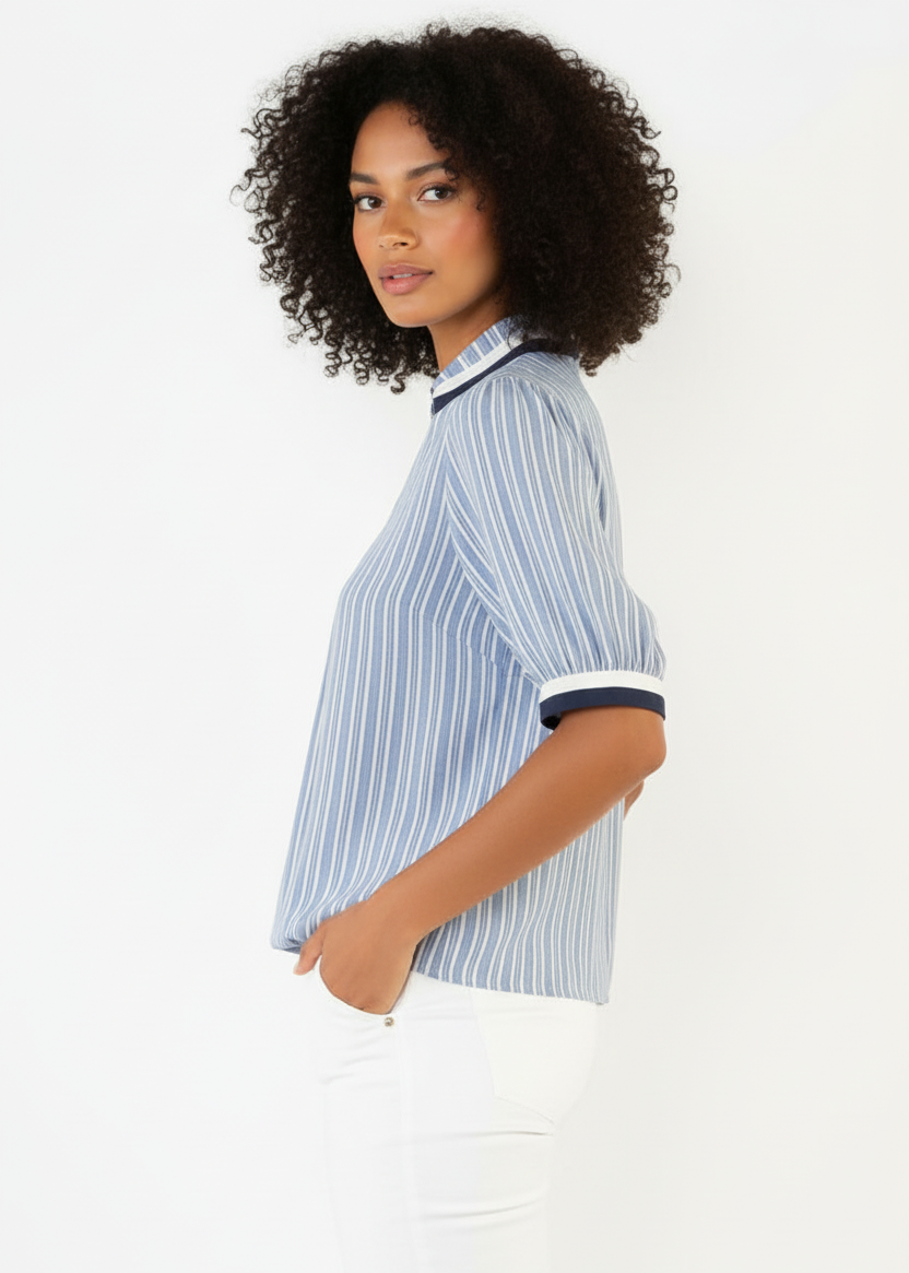 Woman wearing a blue and white striped shirt with a plain background