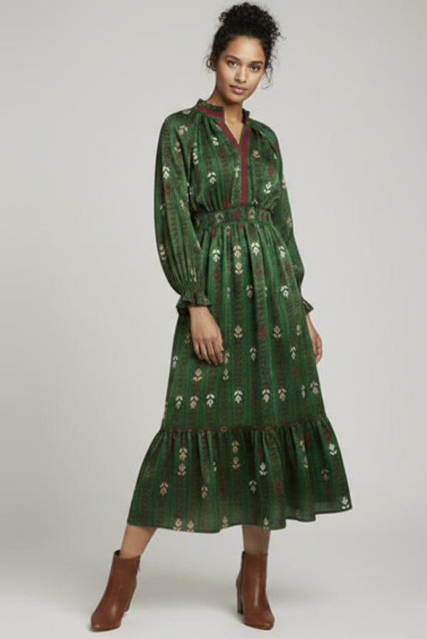 Woman wearing a green patterned dress on a plain background