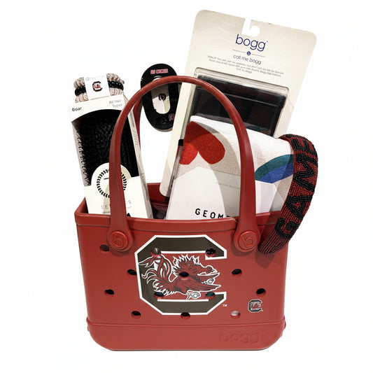 Red bogg bag with a logo, containing various items including a coffee bag and a brush.