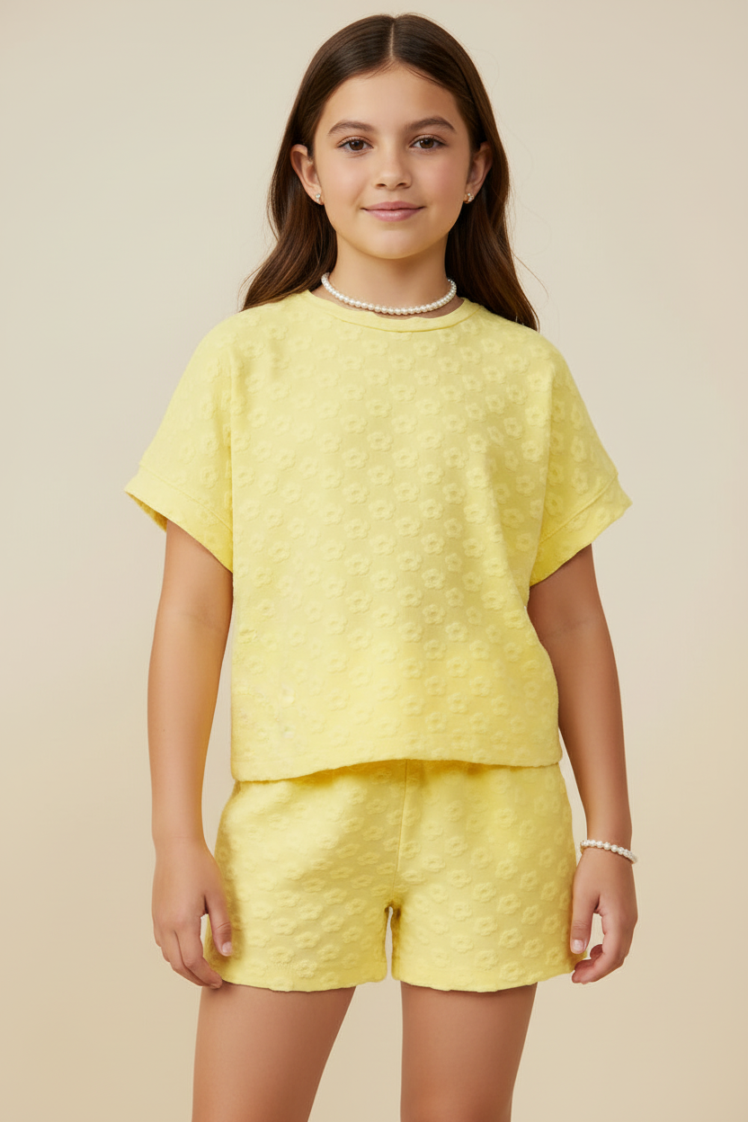 Young girl wearing a yellow textured outfit on a beige background