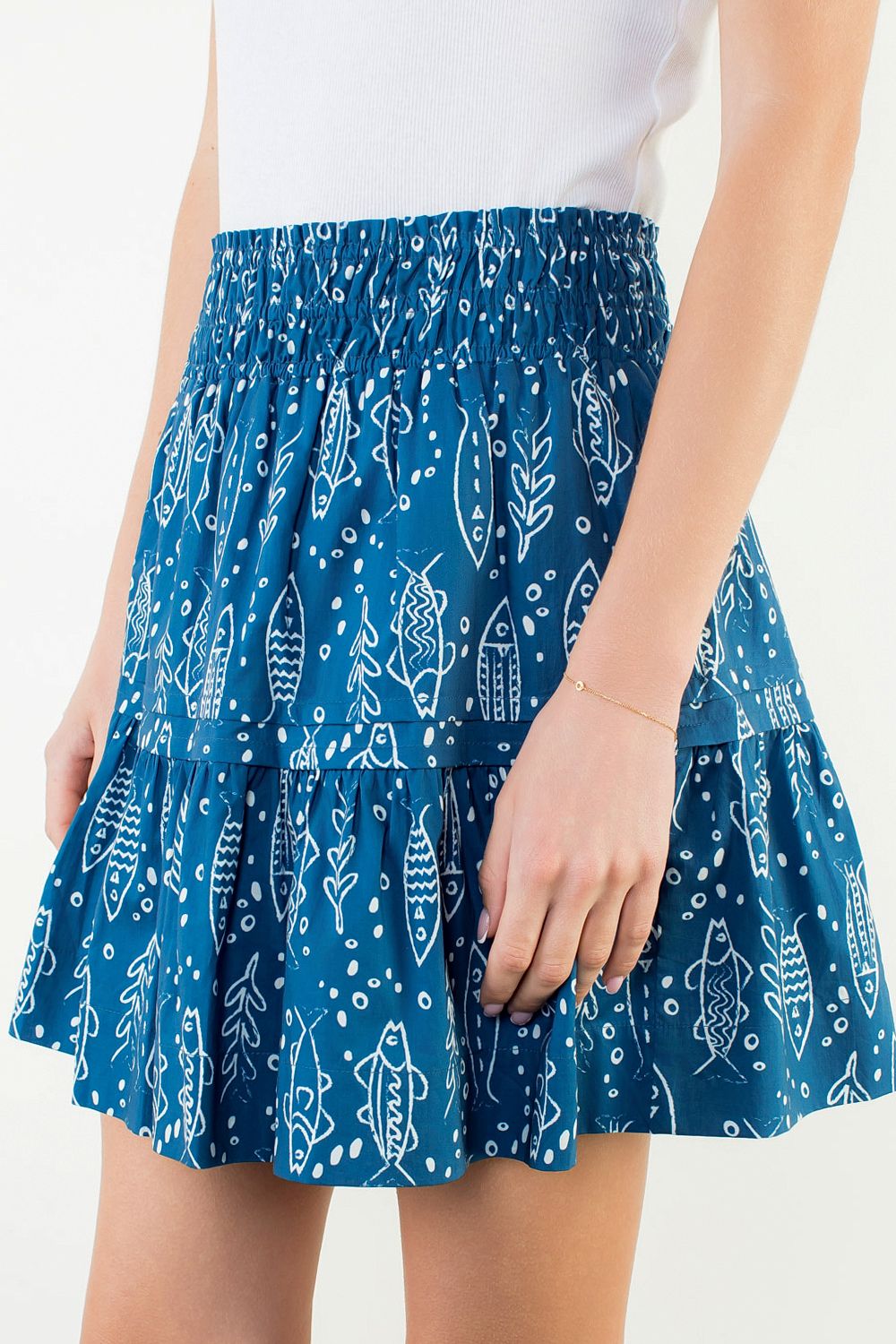Blue patterned skirt worn by a person on a white background