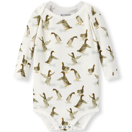 A long-sleeve baby bodysuit by Mållaren, featuring an all-over print of walking ducks on an off-white background. The bodysuit has three snap buttons at the crotch and is photographed flat against a clean white background.