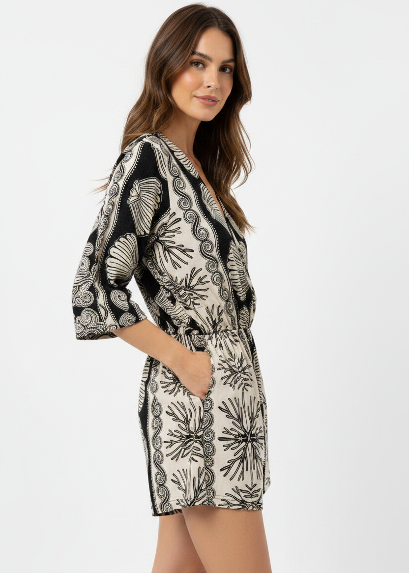 Woman wearing a black and white patterned romper on a white background