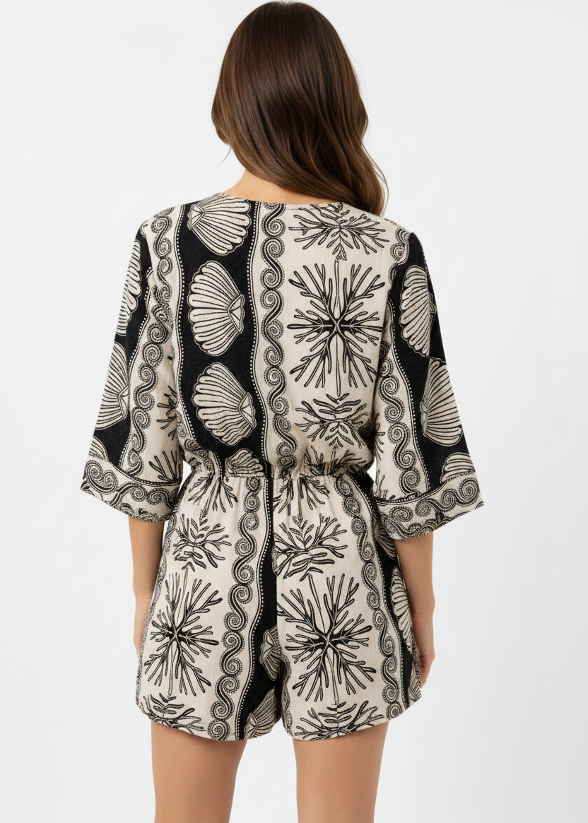 Woman wearing a black and white patterned romper on a white background
