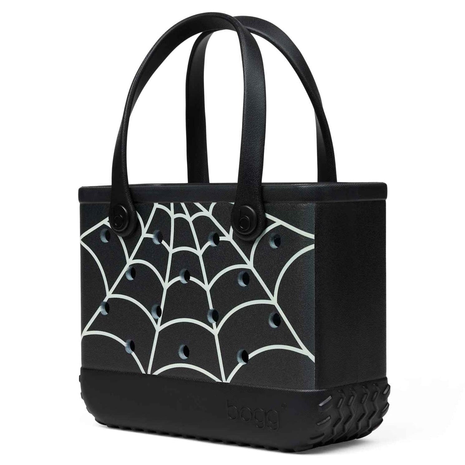 A black Bogg Bag with a white spiderweb pattern, featuring dual top handles and a textured base, shown on a plain white background.