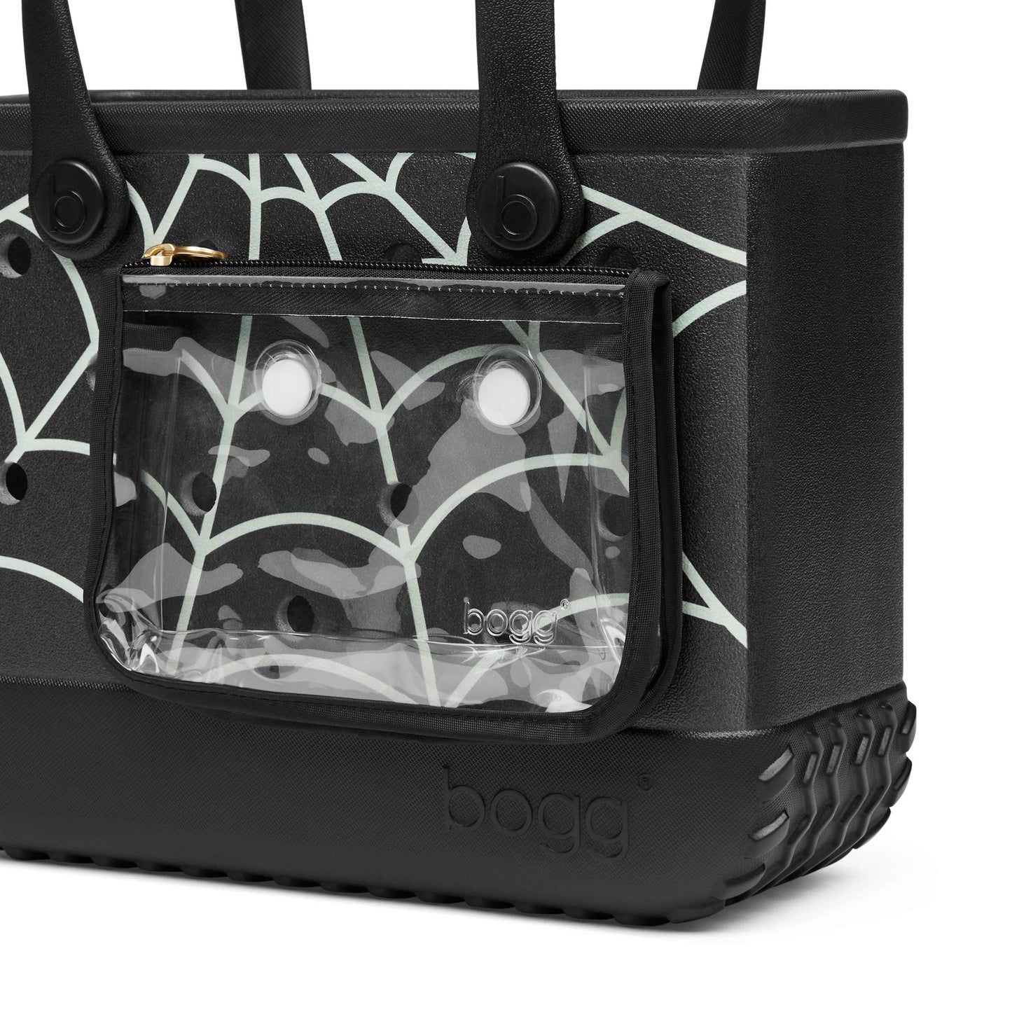 Close-up of a black Bogg bag with a clear front zip pocket showing a matching black and white web pattern, on a white background.