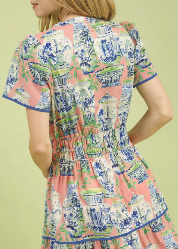 Woman wearing a dress with a colorful pattern on a light green background