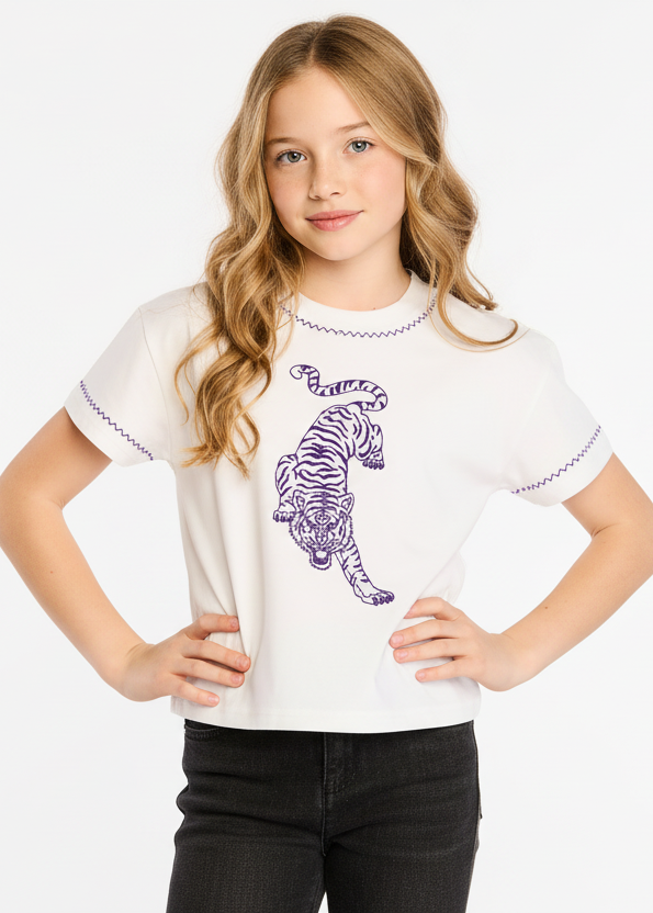 Young girl wearing a white t-shirt with a purple tiger design on a white background