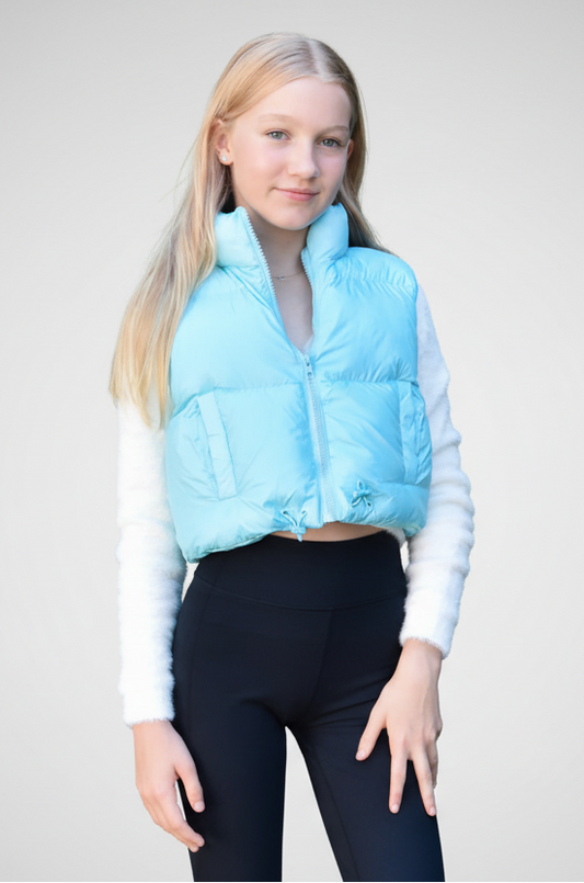 Person wearing a light blue puffer vest over a white long-sleeve shirt on a gray background