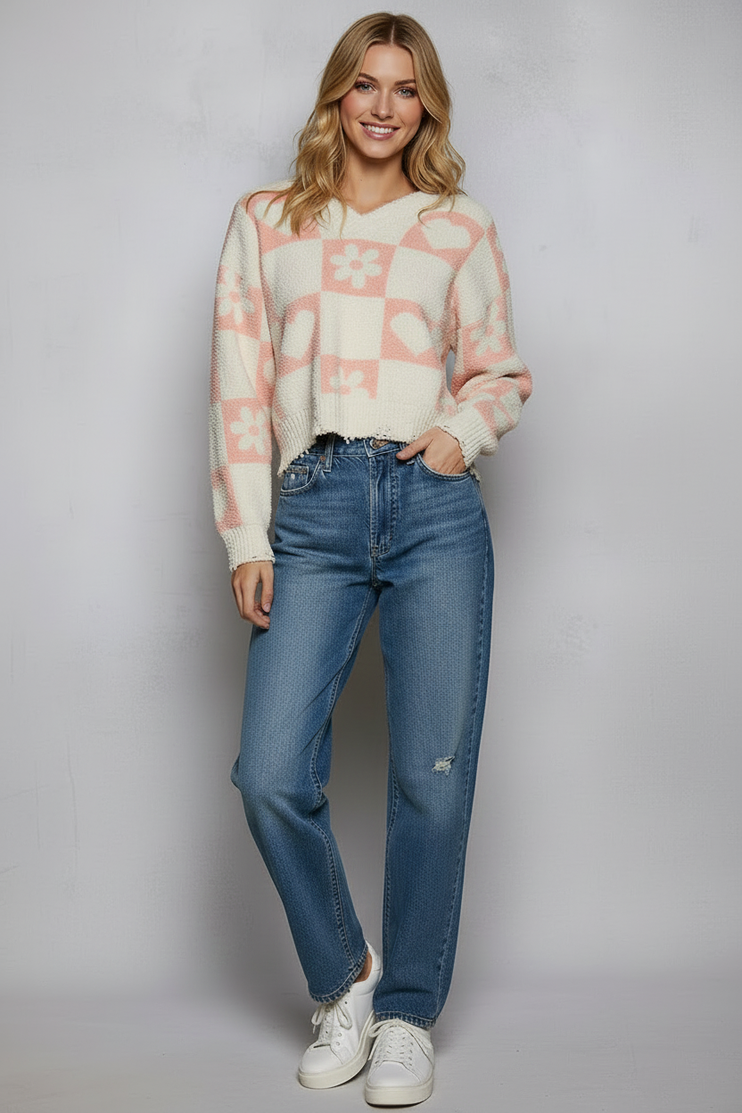 Woman wearing a patterned sweater and blue jeans against a plain background