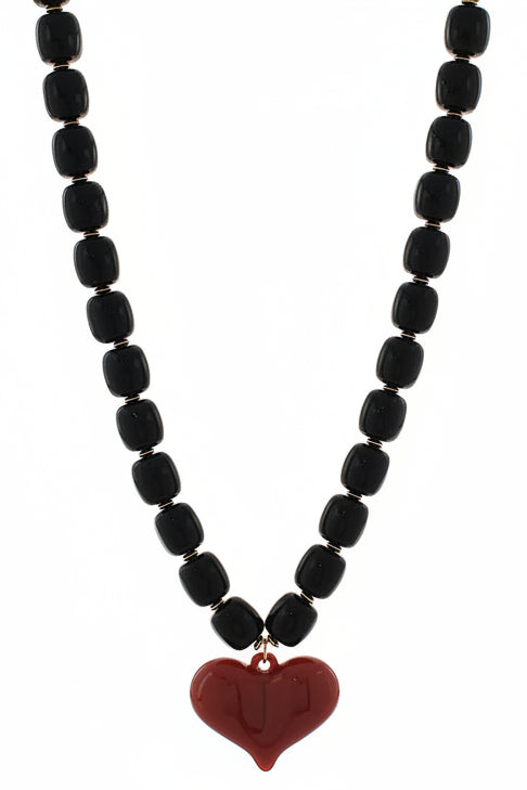 Black beaded necklace with a red heart pendant on a white background