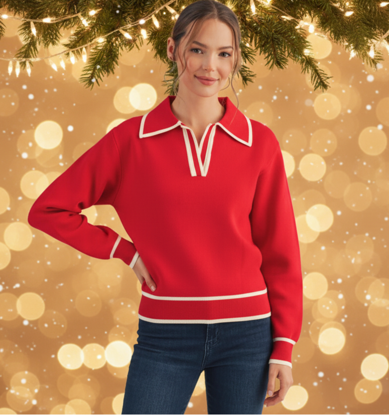 Woman wearing a red sweater with white trim against a festive background with lights and snow.