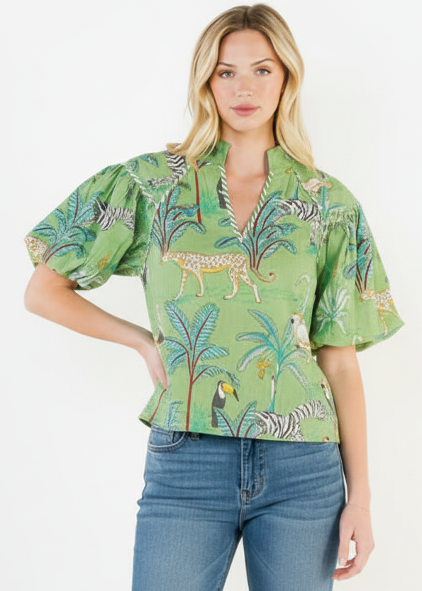 Woman wearing a green tropical patterned shirt with blue jeans on a white background