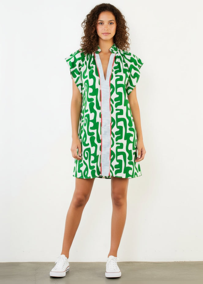 Woman wearing a green patterned dress with a white background