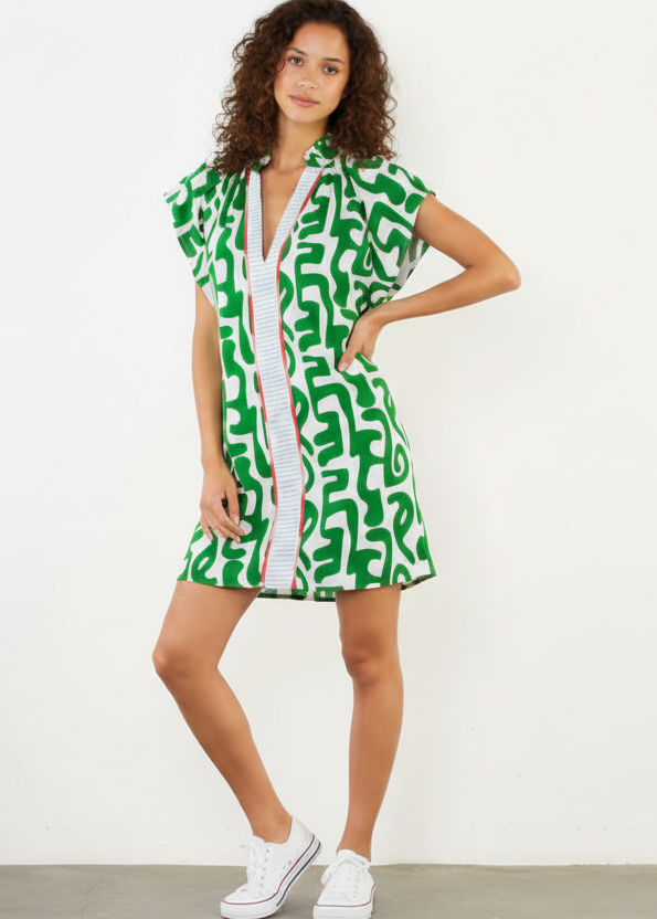 Woman wearing a green patterned dress with a zipper on a white background