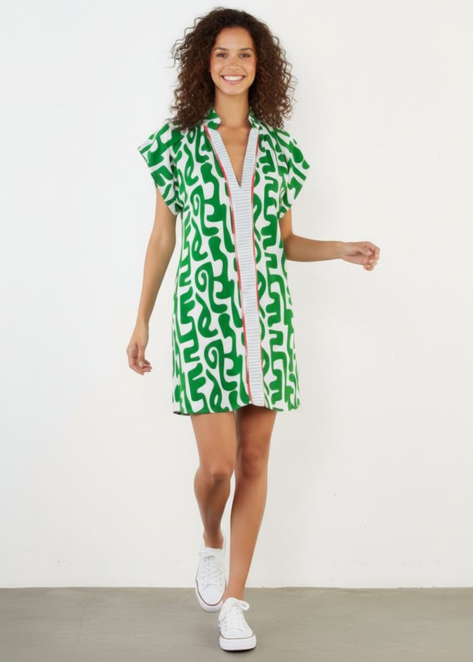 Woman wearing a green and white patterned dress on a plain background