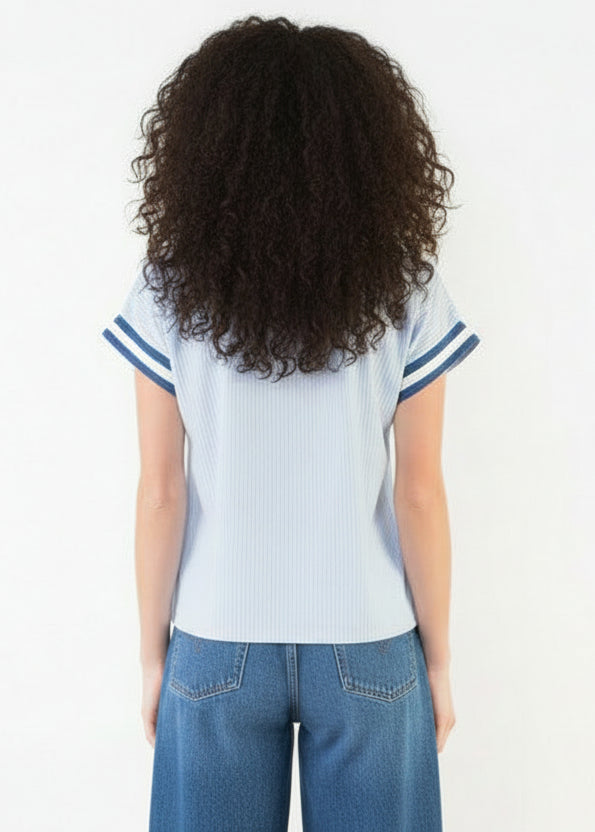 Person wearing a light blue striped shirt and white shorts on a white background