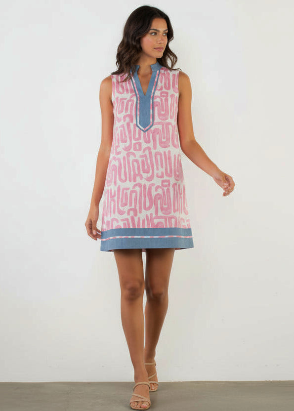 Woman wearing a sleeveless dress with pink and blue pattern on a white background