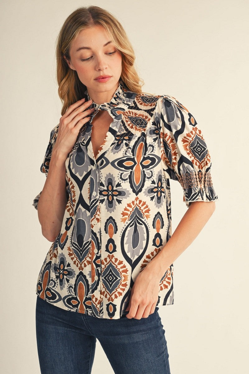 Woman wearing a patterned blouse with a plain background