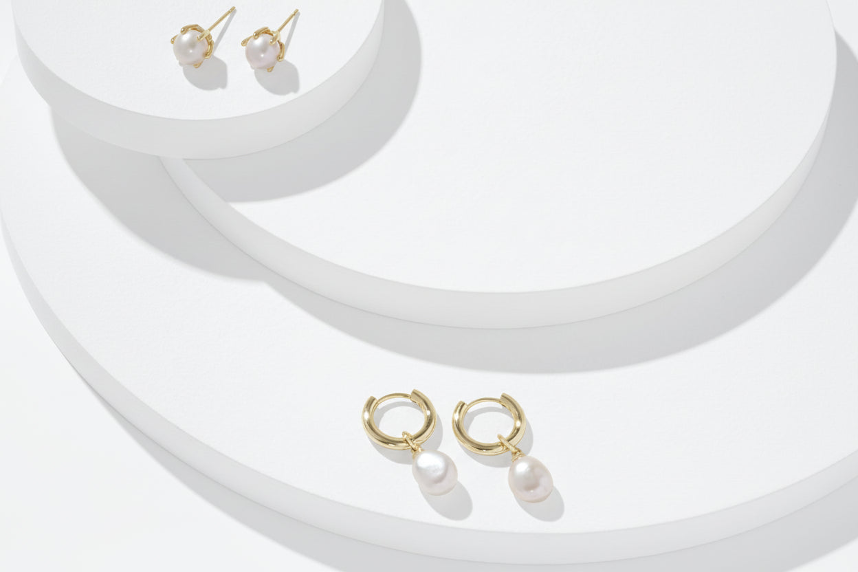 Gold necklace with pearl pendants on a white background