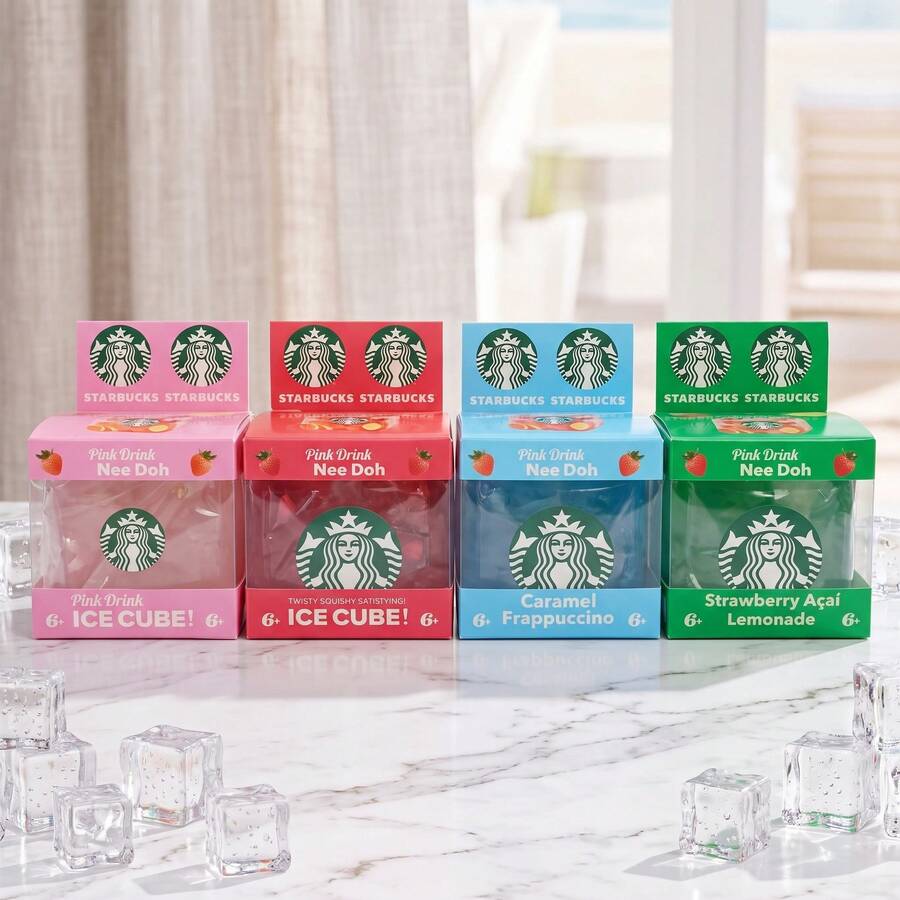 Four Starbucks Nee Doh ice cube boxes in pink, red, blue, and green, arranged on a marble surface with clear ice cubes in the foreground.