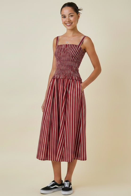 Woman wearing a red and white striped dress against a beige background