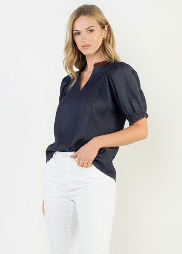 Woman wearing a navy blue top and white shorts on a white background