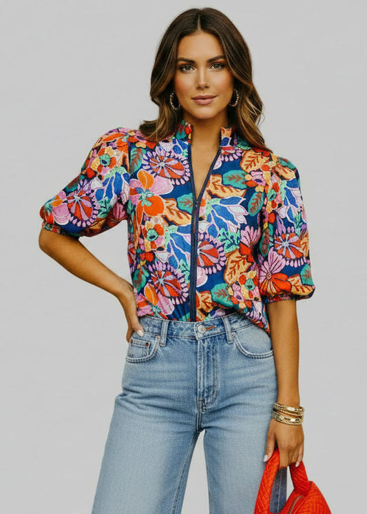 Woman wearing a colorful floral jacket against a plain background