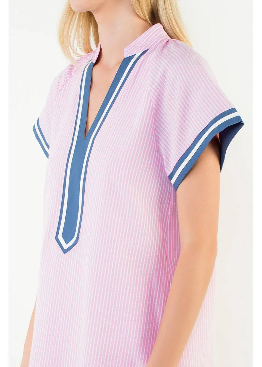 Woman wearing a pink and blue striped dress with a white background