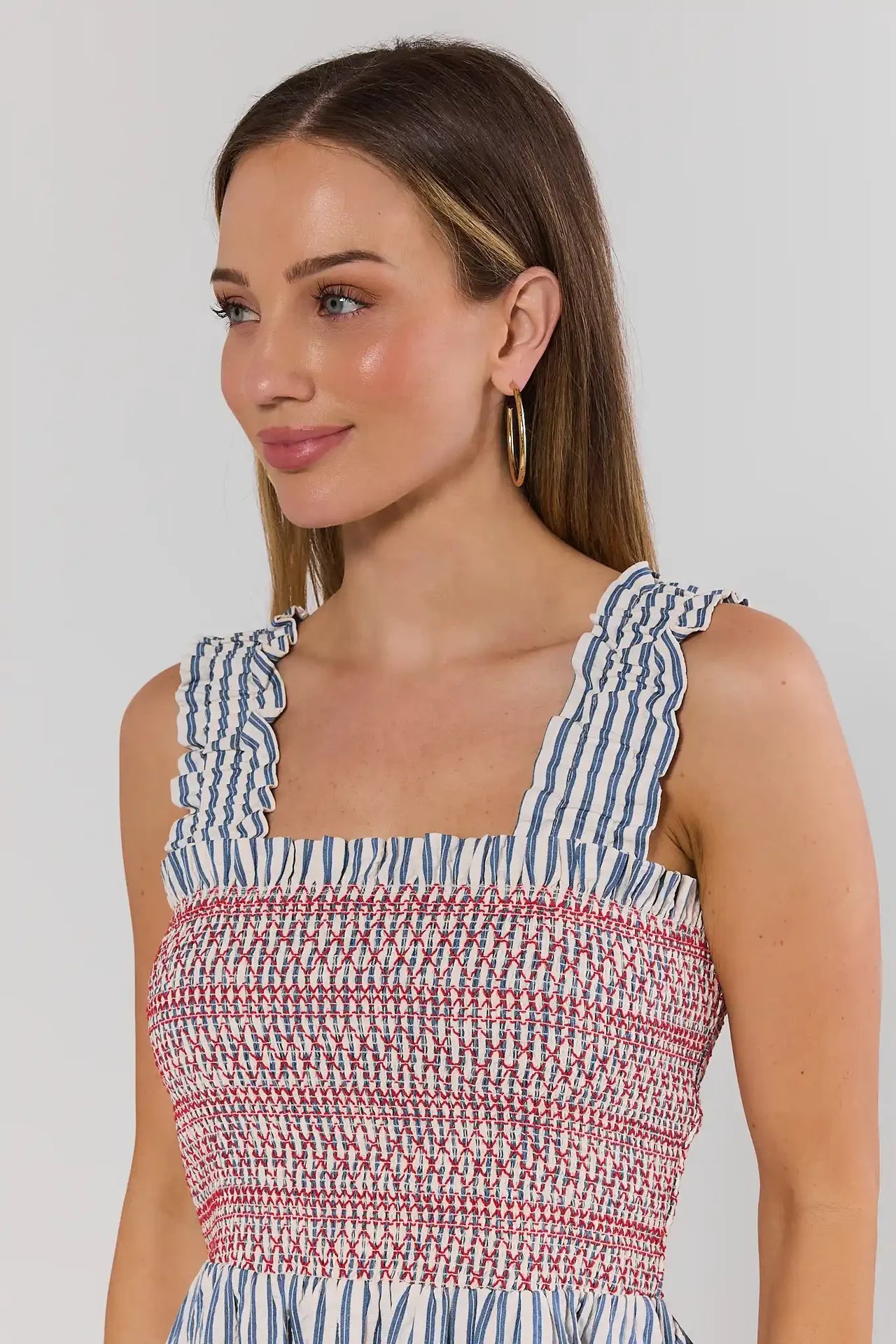 Woman wearing a striped dress with a plain background