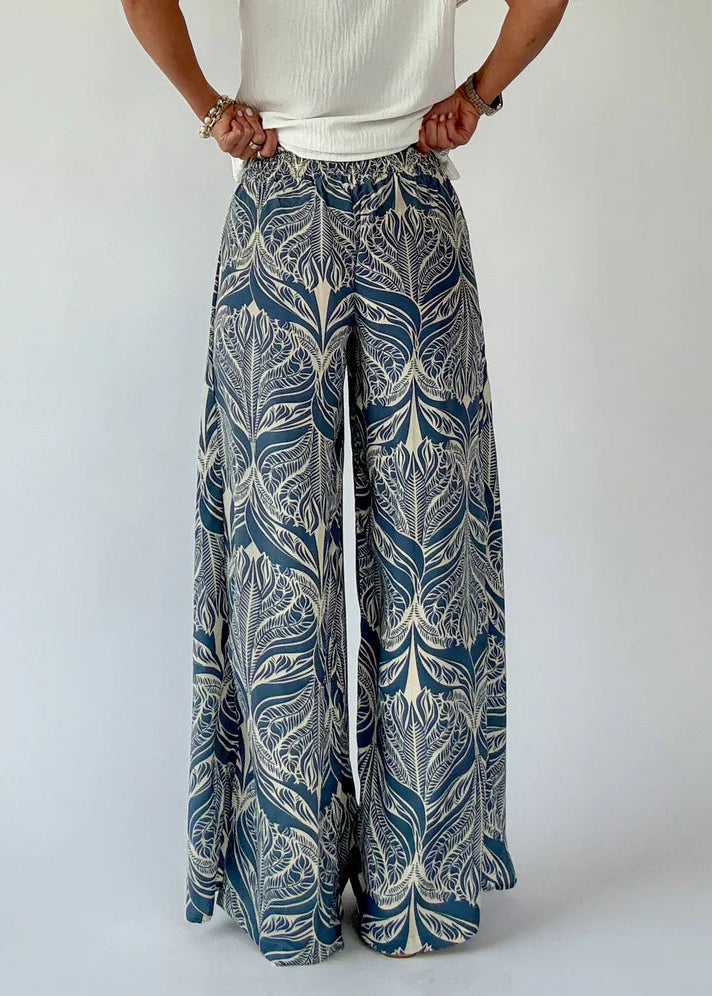 Person wearing patterned wide-leg pants on a white background