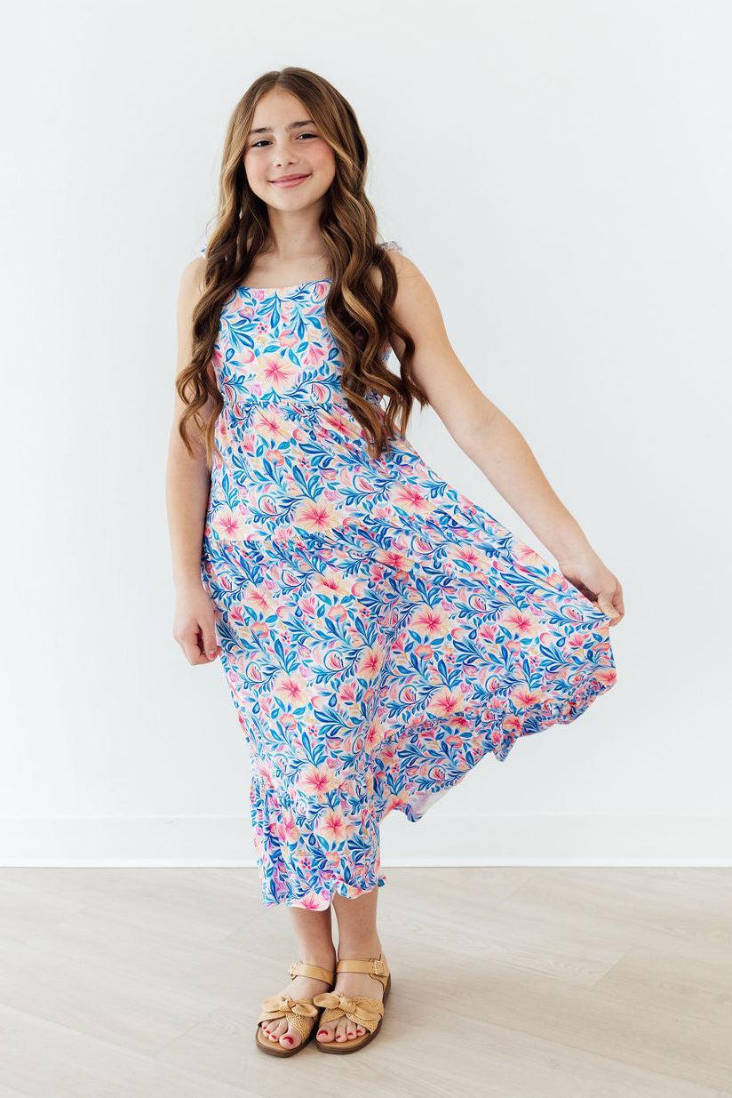 Young girl wearing a floral dress on a white background