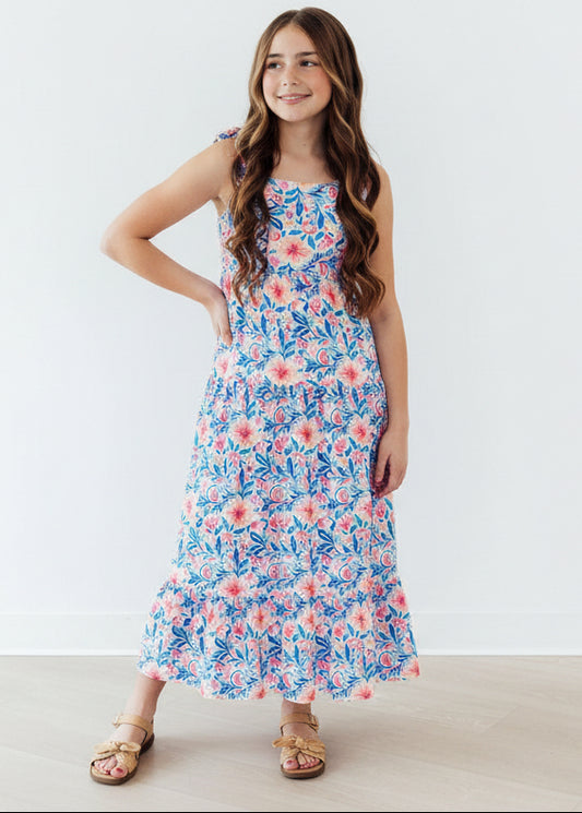 Young girl wearing a floral dress against a white background