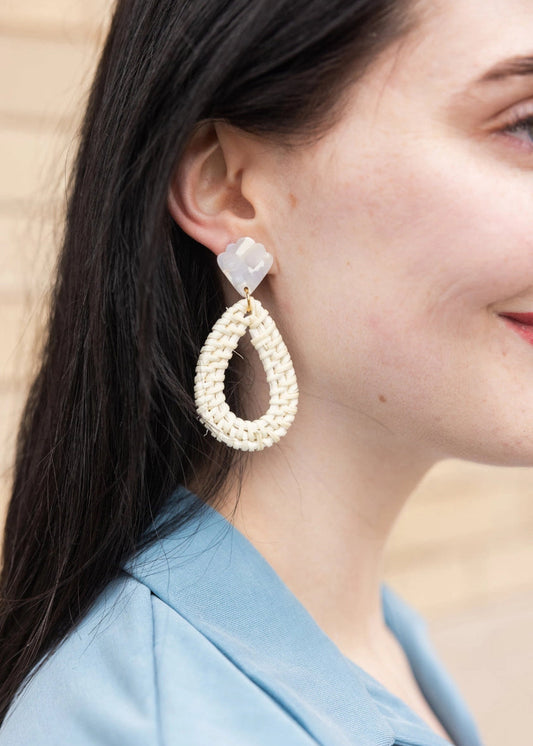Close-up of a person wearing a pair of earrings with a blurred background