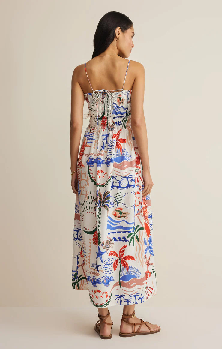 Woman wearing a colorful patterned dress on a plain background