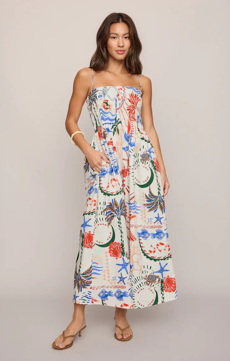 Woman wearing a colorful floral dress on a plain background