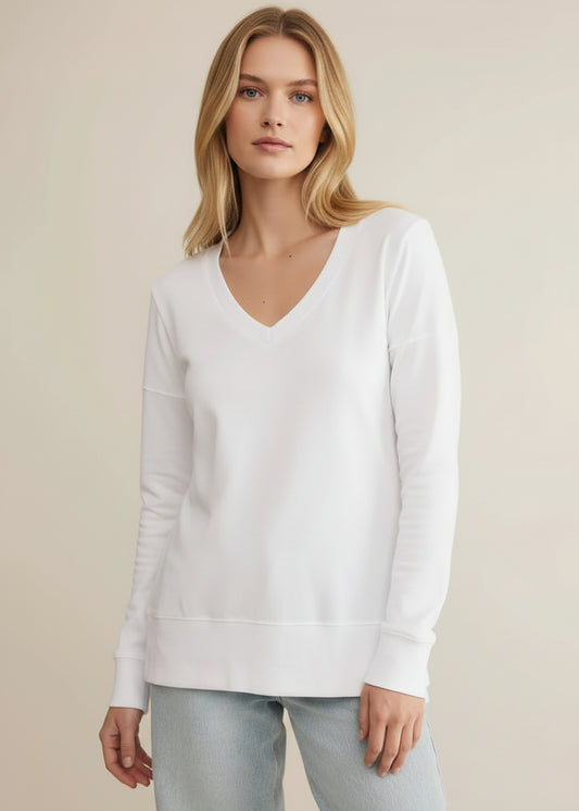 Woman wearing a white sweater against a beige background