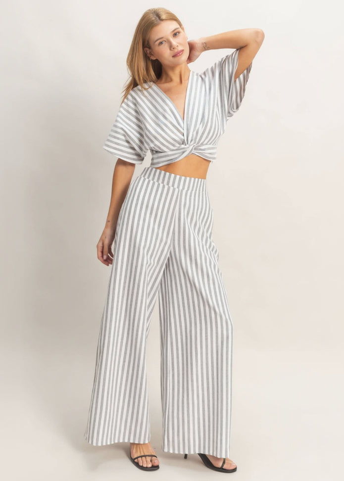 Woman wearing a striped jumpsuit on a plain background