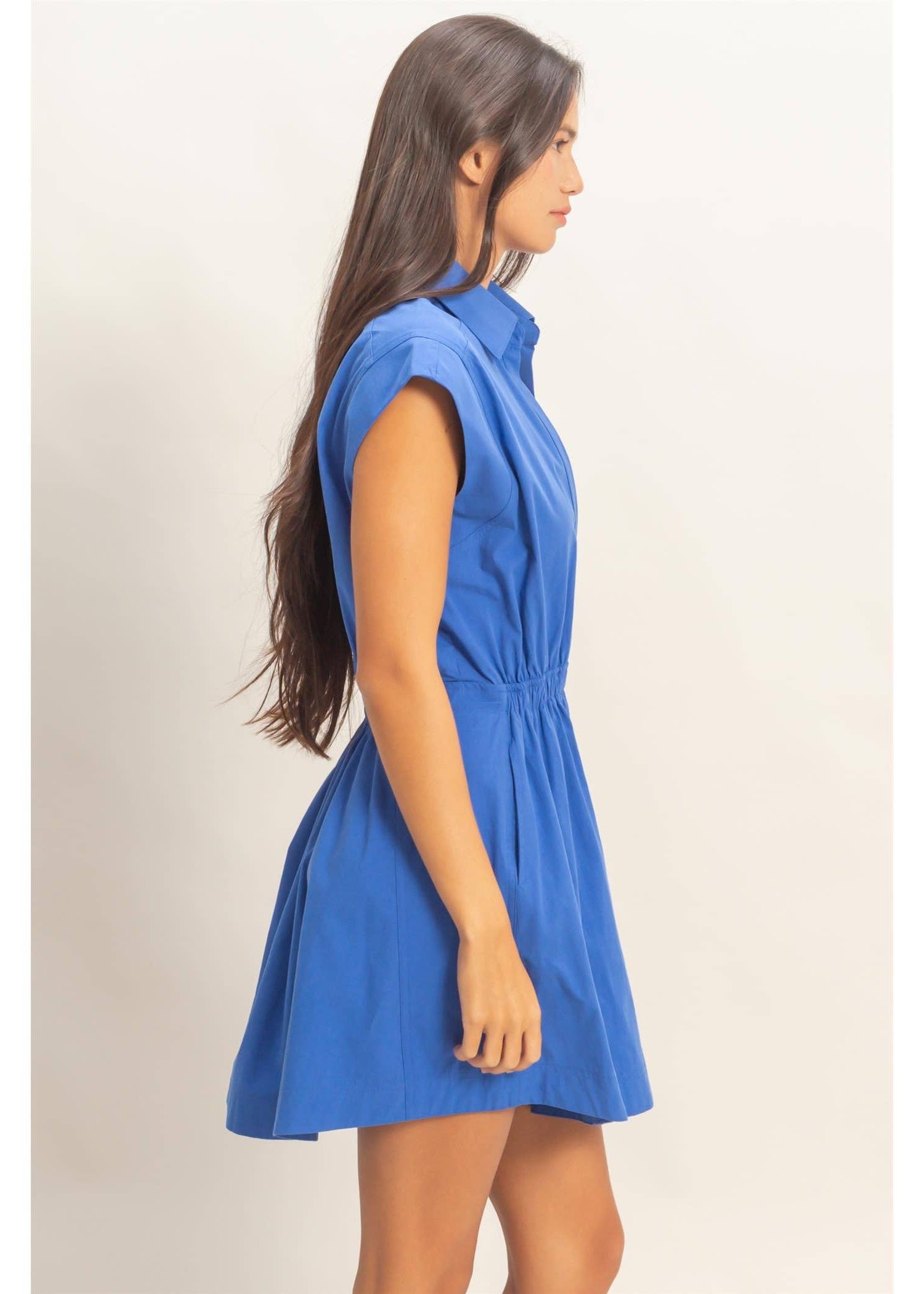 Woman wearing a blue dress against a plain background