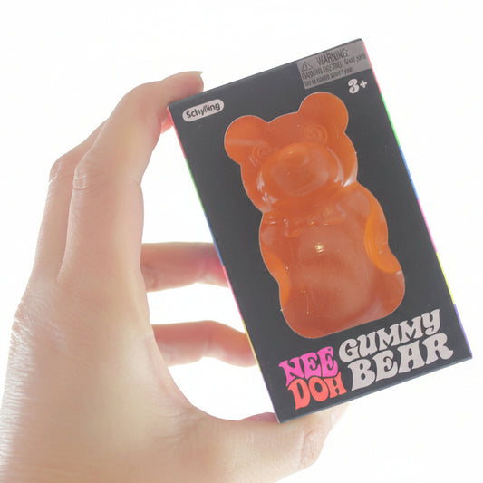 Hand holding a small box with a gummy bear design and 'Curious Minds' branding.