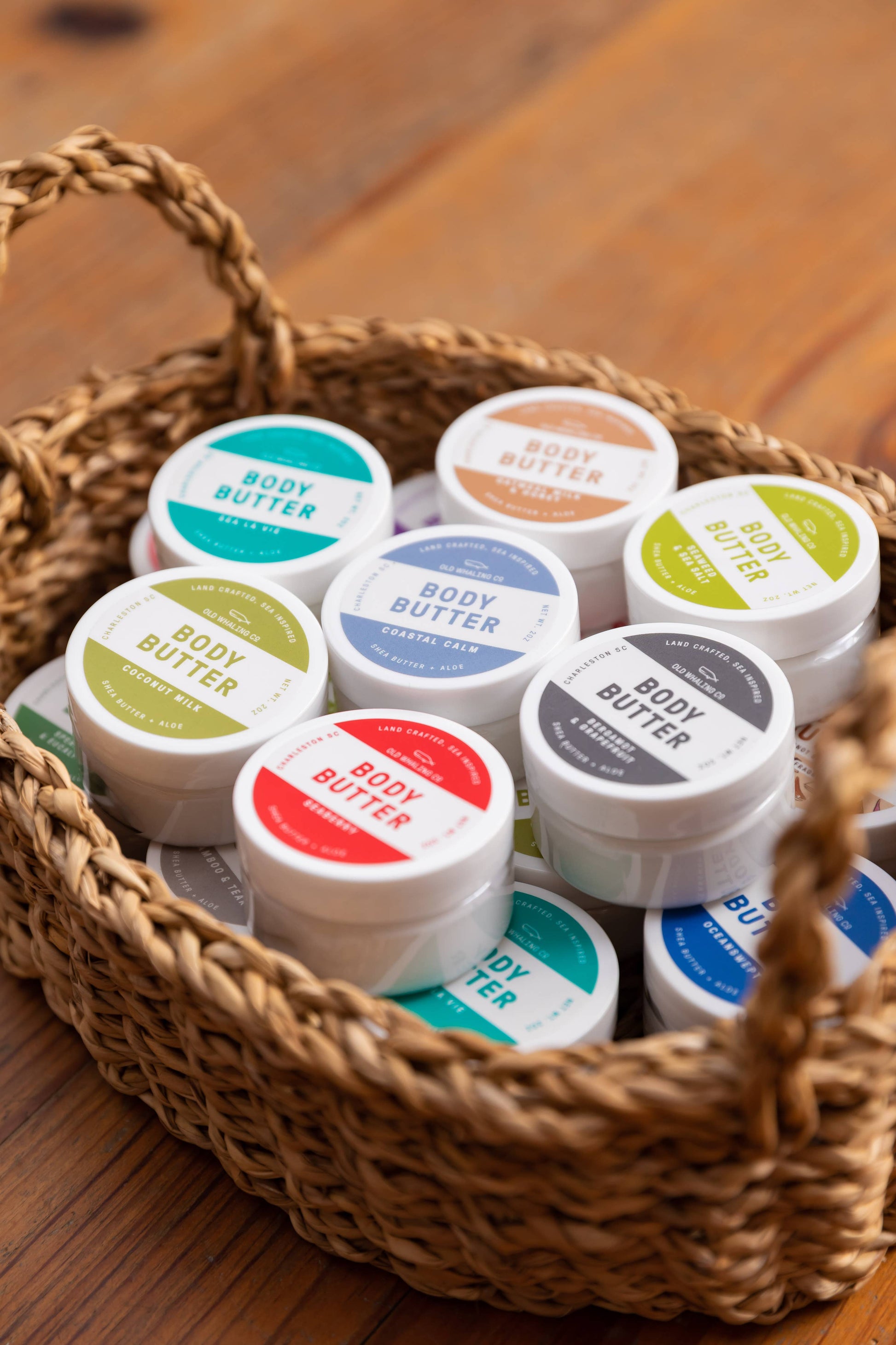 Basket of containers labeled 'Body Butter' on a wooden surface