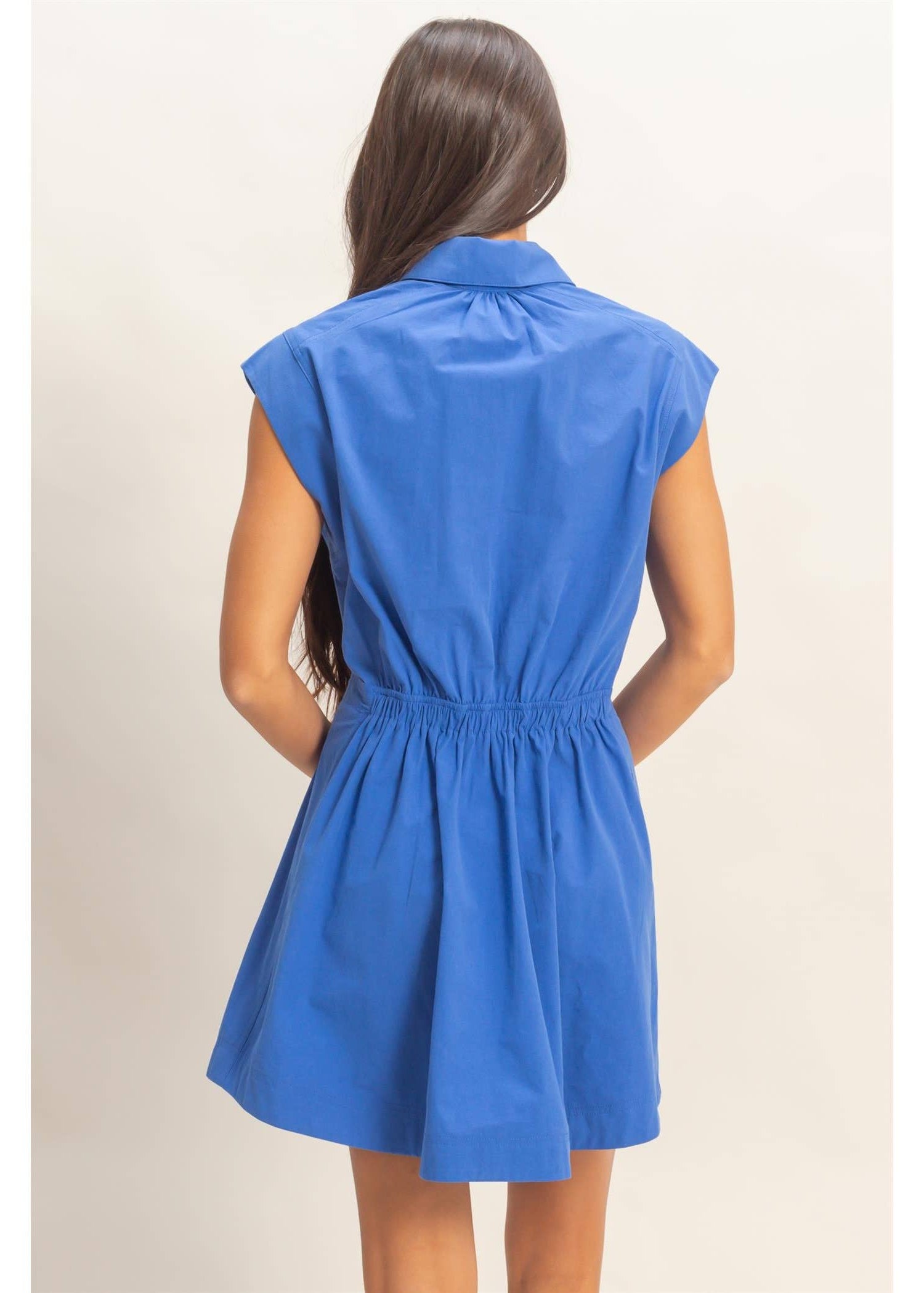 Woman wearing a blue dress on a beige background