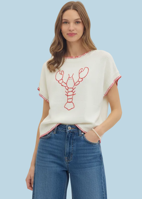 Woman wearing a white t-shirt with red lobster design and blue jeans on a white background