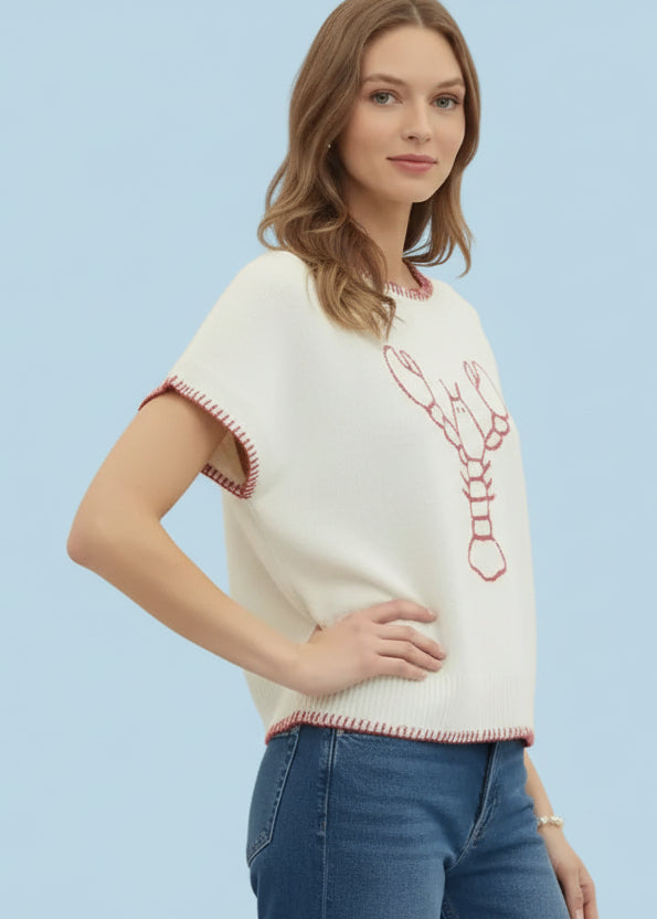 Woman wearing a white sweater with red lobster design and jeans
 on a white background