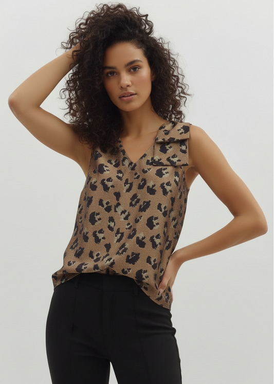 Woman wearing a leopard print sleeveless top against a plain background