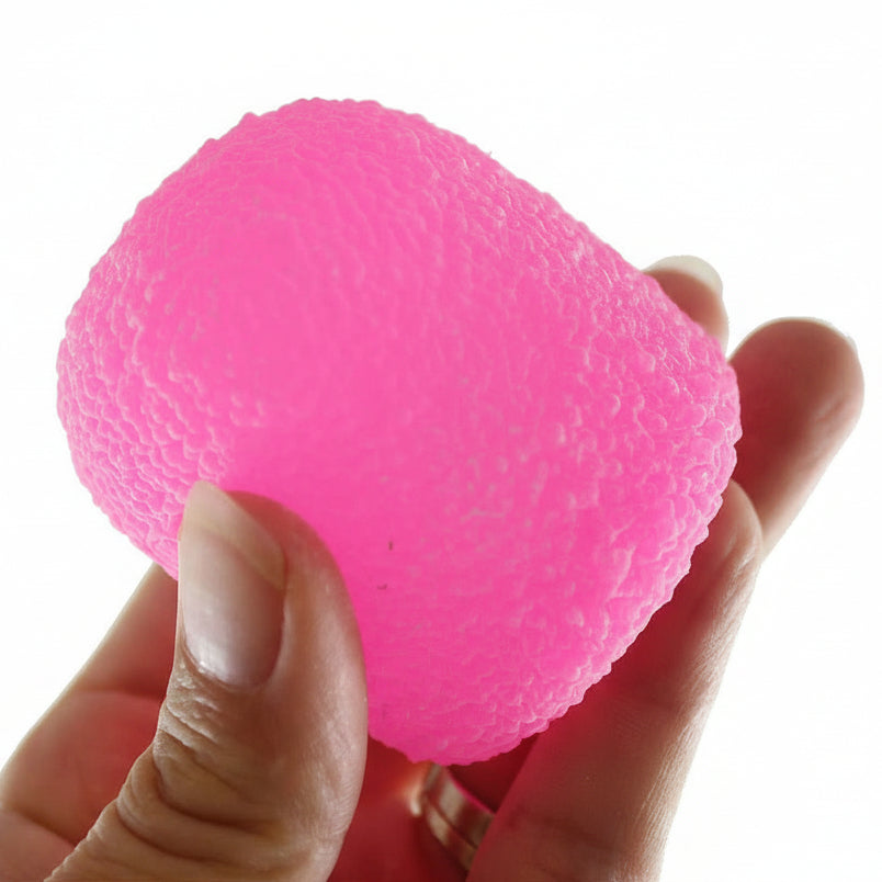 Pink stress ball held in a hand with 'Curious Minds' logo in the corner.