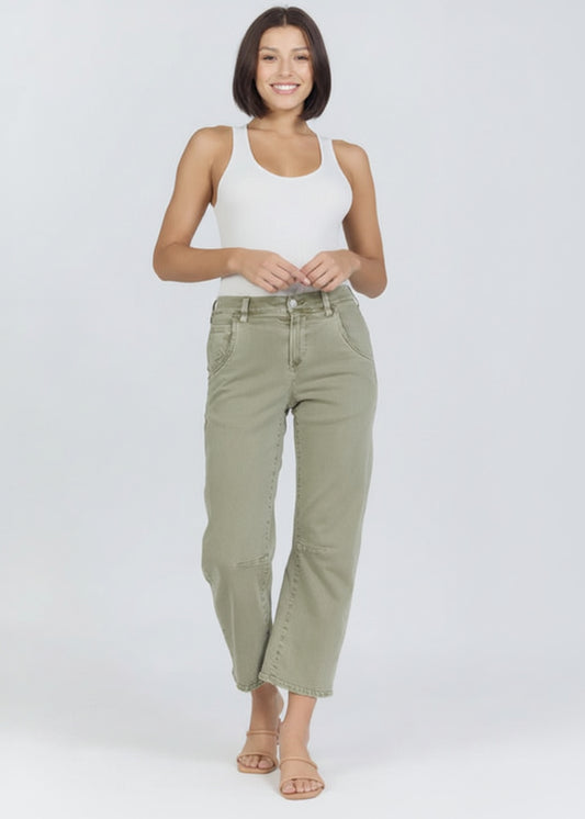 Woman wearing a white tank top and green pants on a white background
