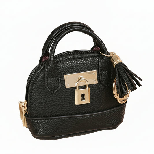 Black handbag with gold accents on a light background with flowers